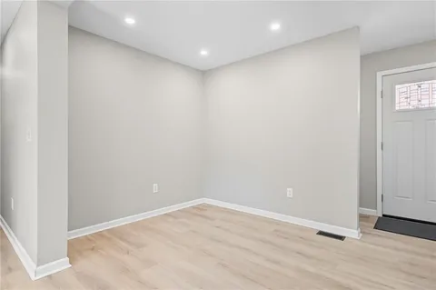 an empty room with wooden floor and white walls