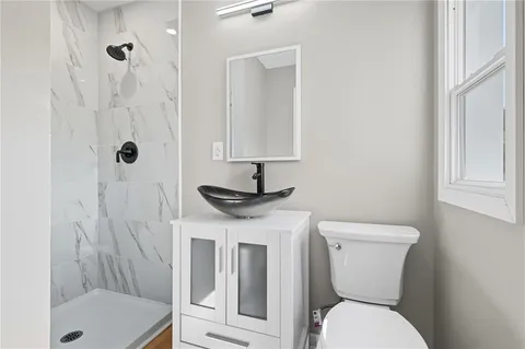 a bathroom with a sink a toilet and shower