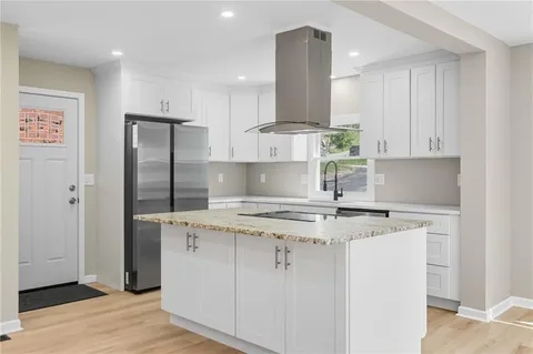 a kitchen with stainless steel appliances granite countertop a sink a refrigerator and a stove
