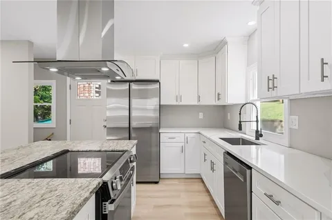 a kitchen with stainless steel appliances granite countertop a sink stove and refrigerator