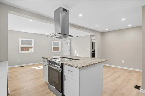 a stove top oven sitting inside of a kitchen