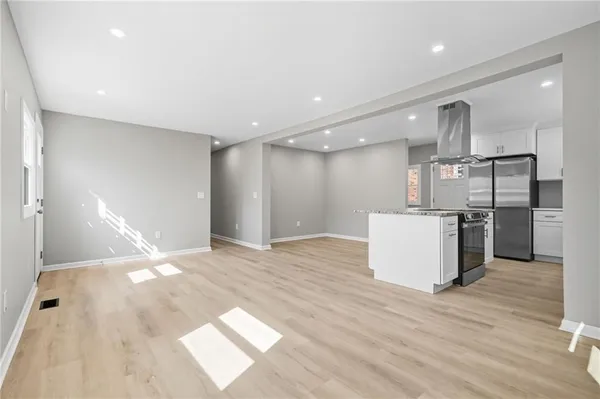 a view of a kitchen with a sink and wooden floor