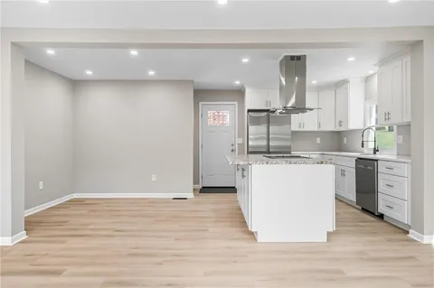 a kitchen with kitchen island a counter top stainless steel appliances and cabinets