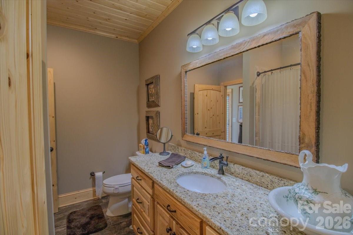 1083 Union Community Road Thurmond, NC 28683 - Photo 20 of 47 a bathroom with a granite countertop sink a mirror and a toilet