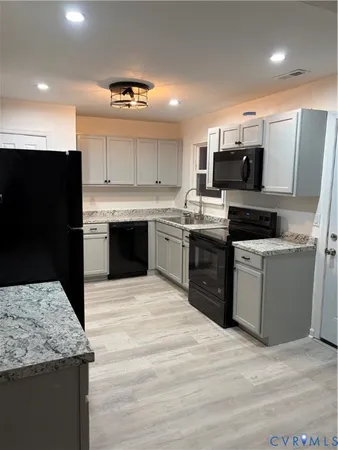 a kitchen with stainless steel appliances granite countertop a stove top oven a sink and a microwave
