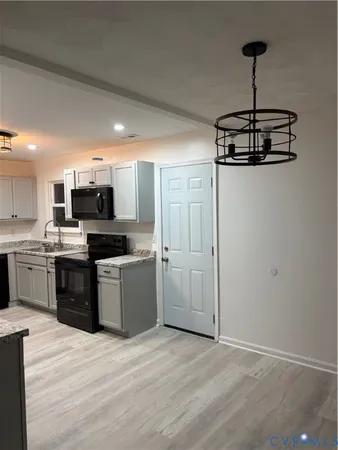a kitchen with granite countertop a refrigerator stove and sink