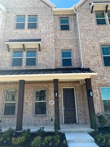 front view of a brick house with a small yard