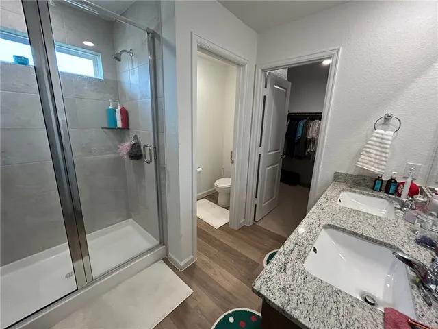 a bathroom with a granite countertop sink a mirror and shower
