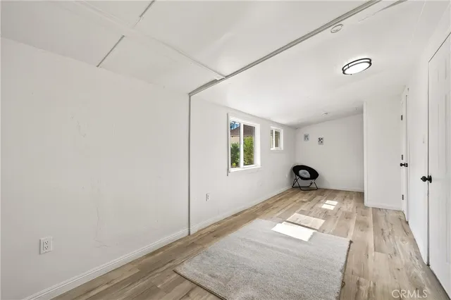 a view of a room with wooden floor and a window
