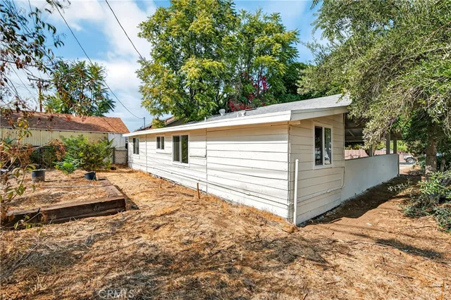 a backyard of a house with plants and tree