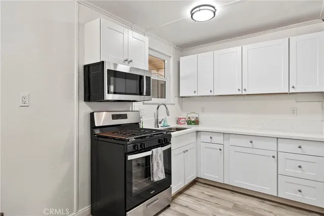a kitchen with granite countertop white cabinets and stainless steel appliances