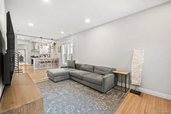 a living room with furniture and a wooden floor