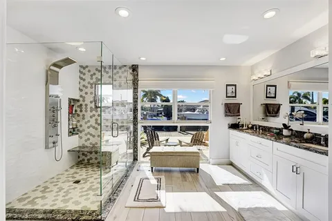 a room with stainless steel appliances kitchen island granite countertop a sink and cabinets