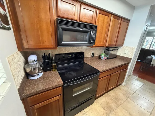 a kitchen with granite countertop wooden cabinets and a stove top oven