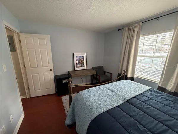 a bedroom with a bed and wooden floor