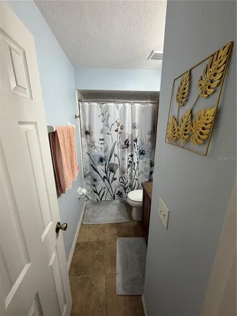 a view of a livingroom with chair and floor to ceiling window