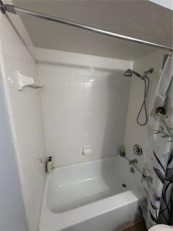 a bathroom with a bath tub with a shower