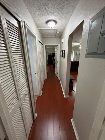 a view of a hallway with wooden floor and staircase