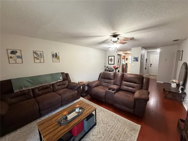a living room with furniture a ceiling fan and a rug