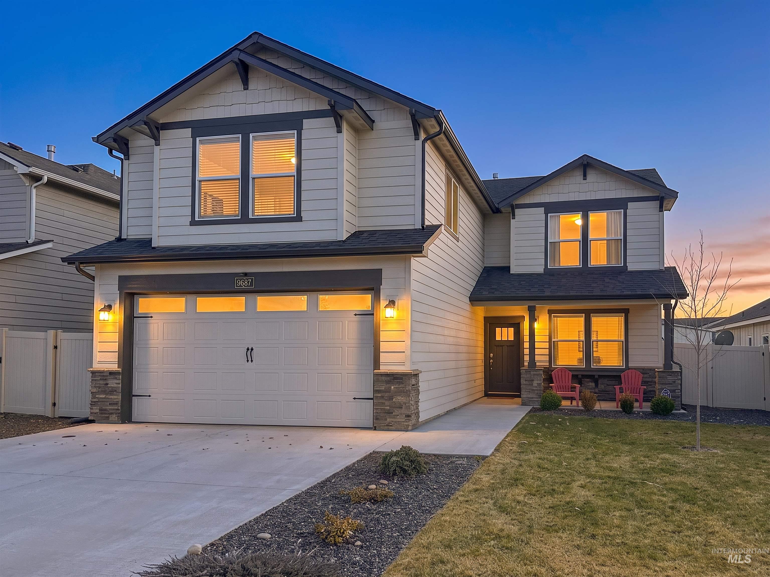 9687 West Arnold Road Boise, ID 83714 - Photo 1 of 37 Two-story residence featuring light-colored siding with dark trim, a two-car garage, and a covered front porch
