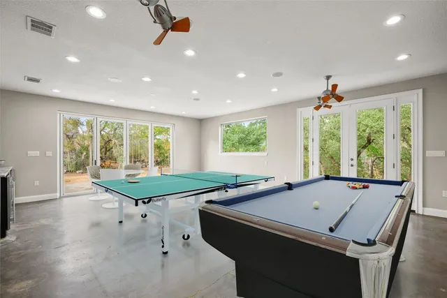 a room with pool table and windows