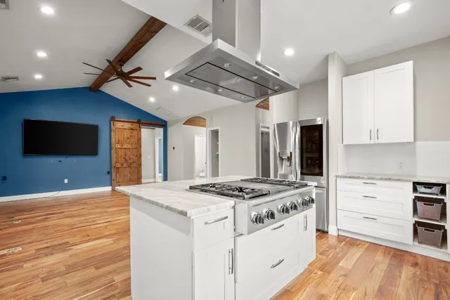 a kitchen that has a stove and a wooden floor