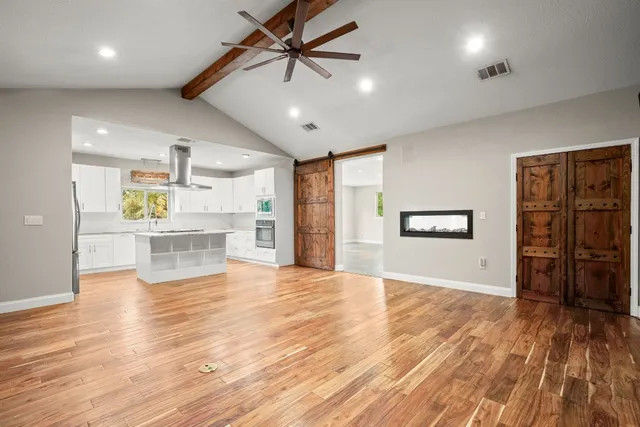 a view of a kitchen with a wooden floor and a ceiling fan