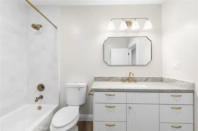 a bathroom with a toilet sink vanity tub and shower