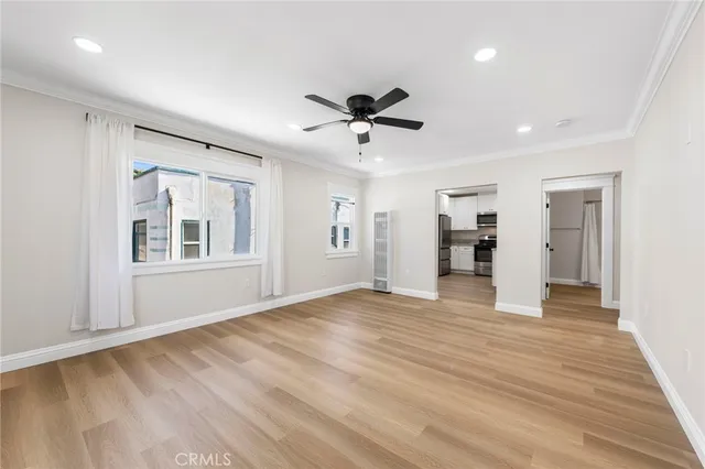 a view of an empty room with a window and wooden floor