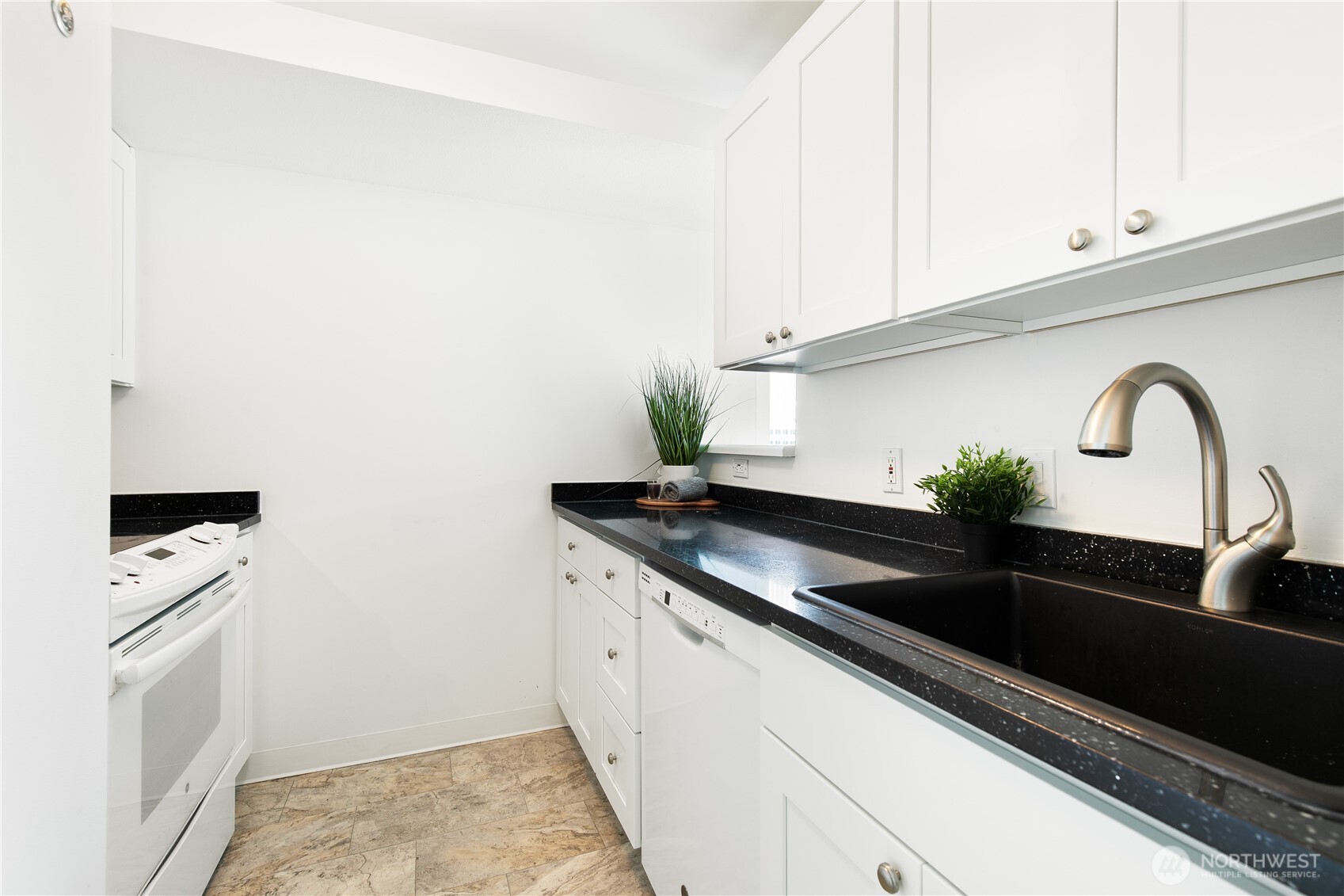 1415 2nd Avenue, Unit 1607 Seattle, WA 98101 - Photo 12 of 40 a kitchen with granite countertop white cabinets and a stove