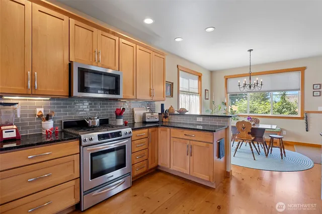 a kitchen with granite countertop a stove a sink and a microwave