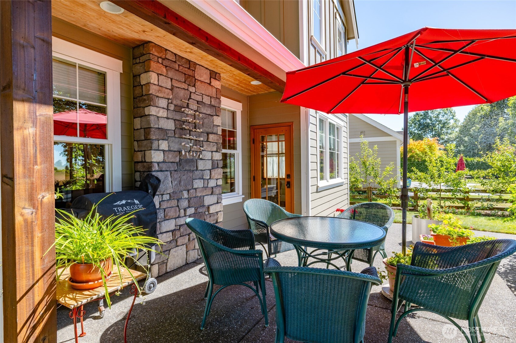 1739 Emerald Way Lynden, WA 98264 - Photo 37 of 40 a patio with a table and chairs under an umbrella