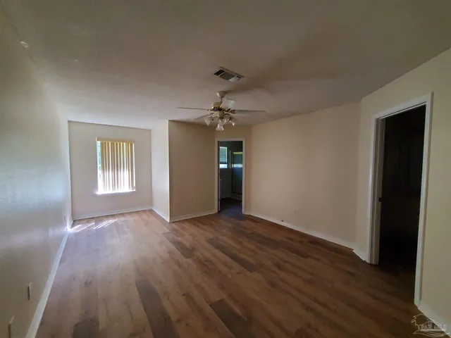 a view of an empty room with wooden floor