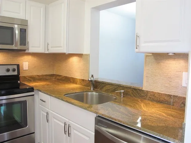 a kitchen with granite countertop a sink and cabinets