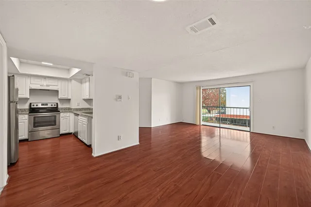 a view of kitchen with refrigerator and wooden floor