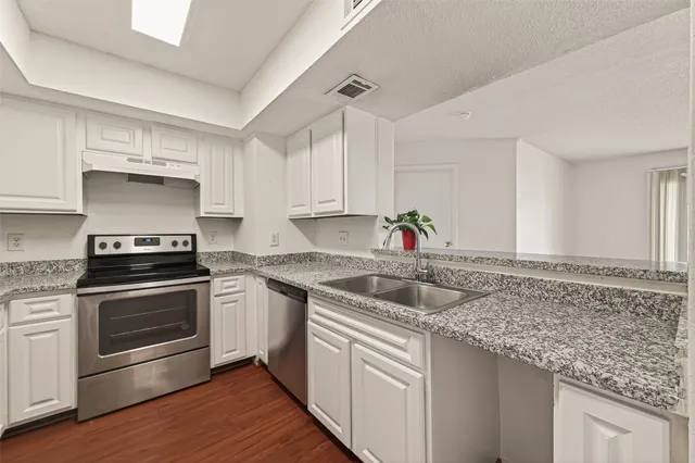 a kitchen with stainless steel appliances granite countertop a sink stove and cabinets