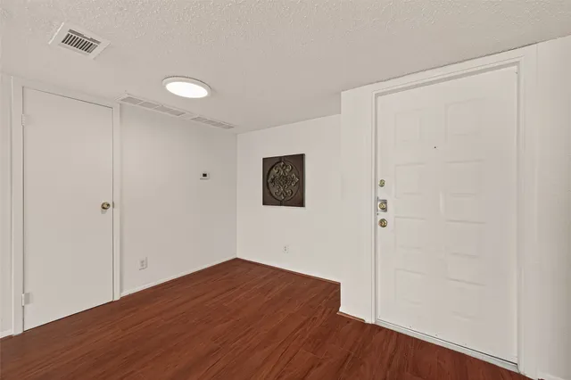 a view of a big room with wooden floor and windows in a room