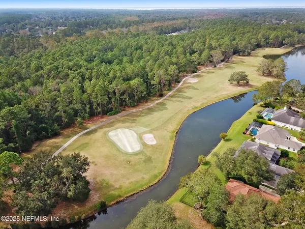 an aerial view of a house with a yard and lake view