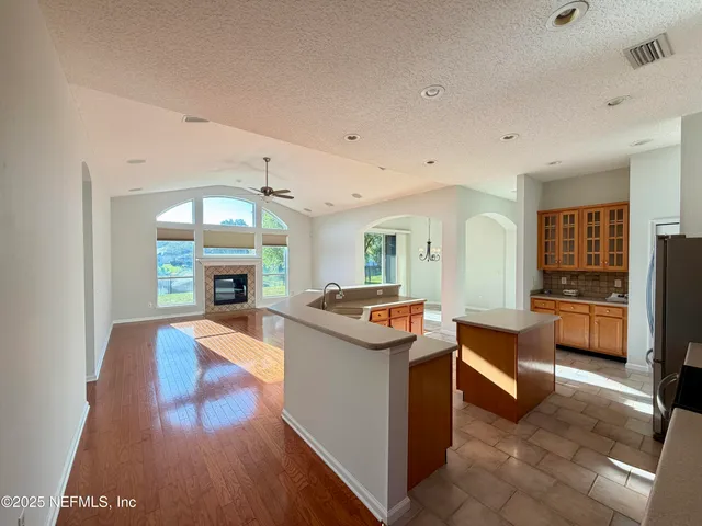 a kitchen with granite countertop a refrigerator and a stove top oven