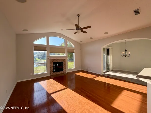 a view of an empty room with a fireplace and a window