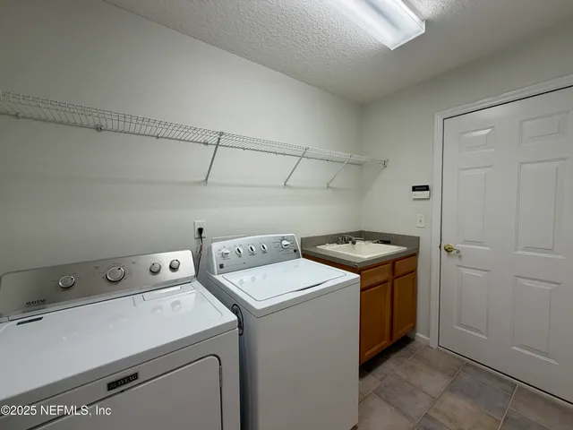 an empty room with wooden floor chandelier fan and windows