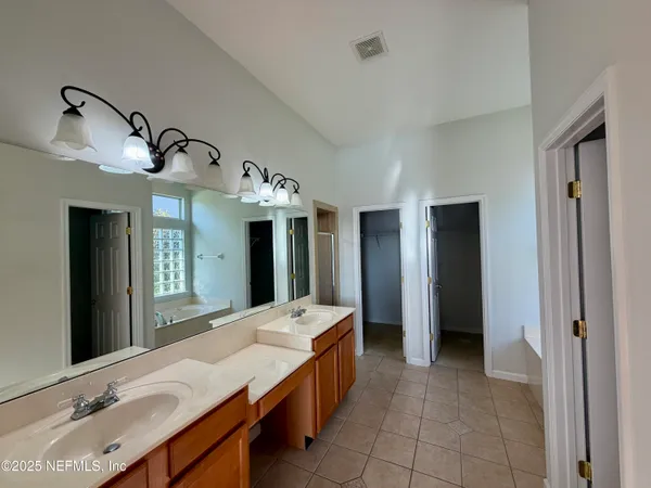 a large bathroom with a double vanity sink and a large mirror