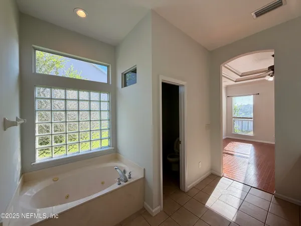 a bathroom with a tub shower and window