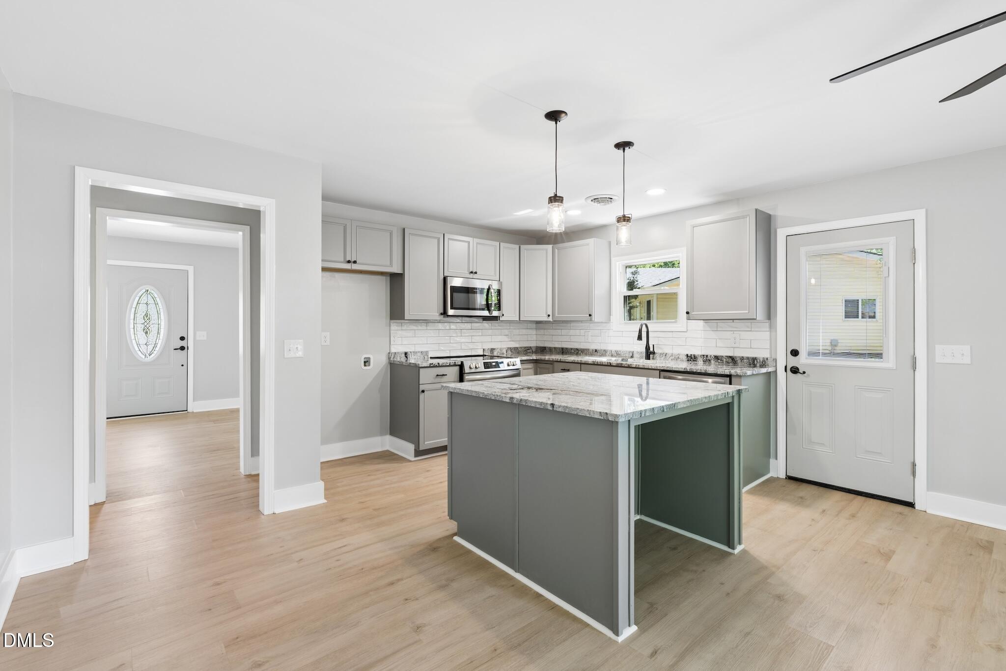 1200 Armstrong Circle Raleigh, NC 27610 - Photo 7 of 28 a kitchen with kitchen island granite countertop a sink cabinets and wooden floor