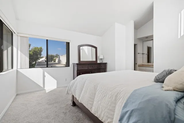 a bedroom with a large bed and a large mirror