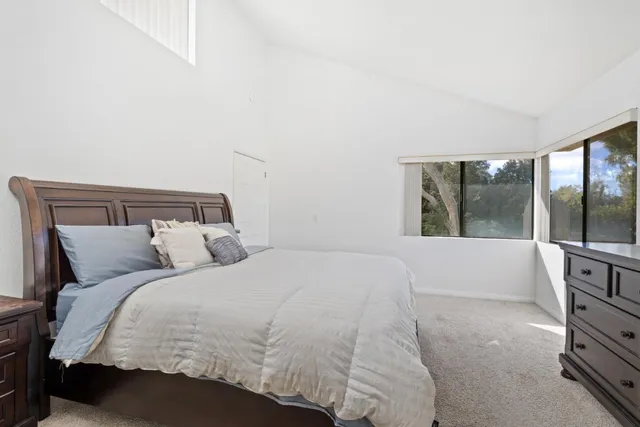 a spacious bedroom with a bed and cabinet