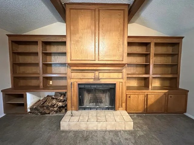 a living room with a fireplace cabinet and a fireplace