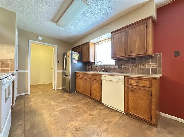 a kitchen with a refrigerator sink and cabinets