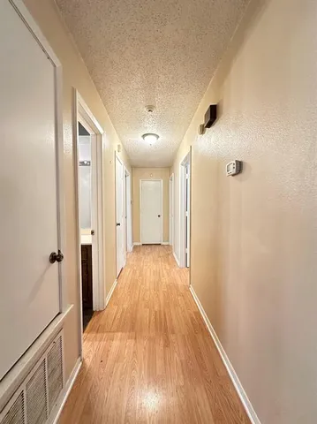 a view of a hallway with wooden floor and staircase
