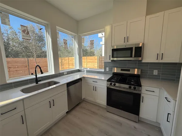 a kitchen with appliances a sink and a window